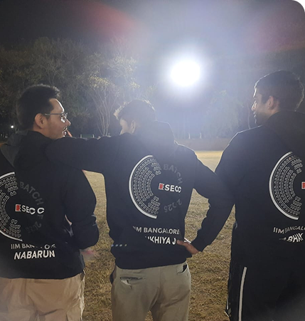 Three IIM Bangalore students showing the personalised back prints on their black hoodies