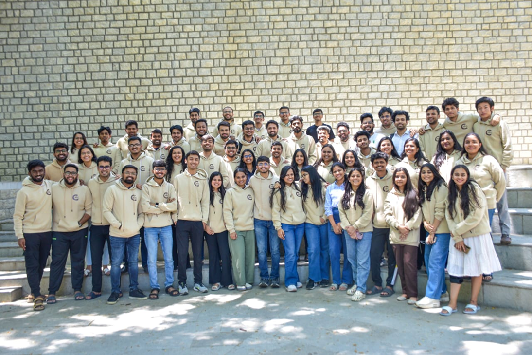 IIM Bangalore cohort together on campus in matching cream hoodies